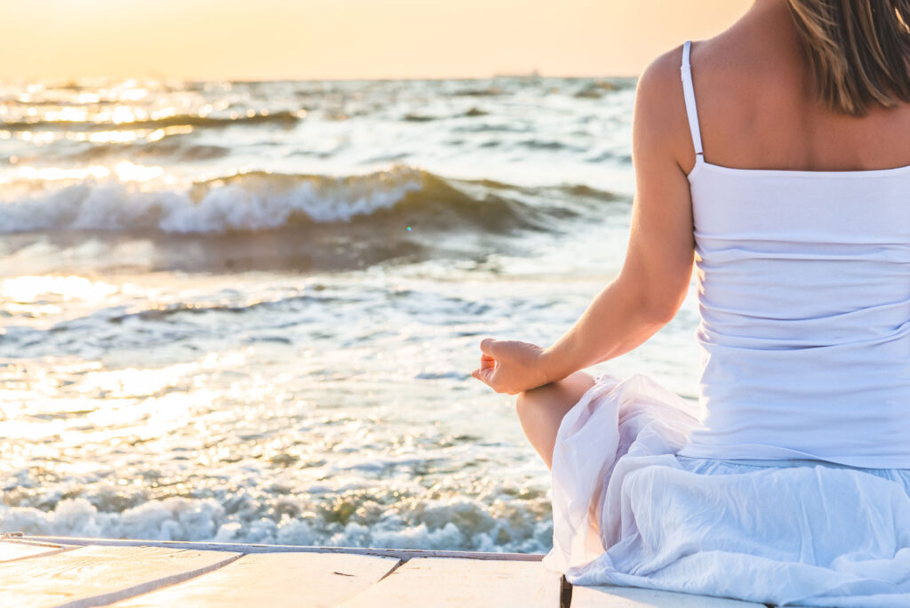 Medytacja, joga nad brzegiem oceanu.